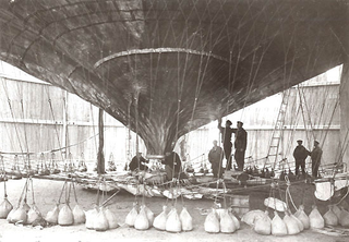 El Águila con sacos de arena que mantienen el globo lleno de hidrógeno en tierra previa partida. Wikimedia Commons